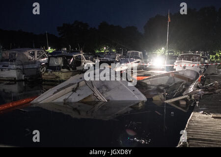 Minden, Deutschland. 12. Juli 2017. Die zerstörte Motoryacht "Gina" liegt im Hafenbecken halb versunkenen in Minden, Deutschland, 12. Juli 2017. Bei der Explosion einer Motoryacht am Hafen in Minden wurden zwölf Feuerwehrleute und Polizisten verletzt. "Sechs von Ihnen Erlitten zurück Verletzungen. Einer Schwebt in Lebensgefahr "(lit.) Sechs von ihnen erlitten schwere Verletzungen, stellt eine Gefahr für das Leben), sagte einen Sprecher der Polizei. Foto: Federico Gambarini/Dpa/Alamy Live News Stockfoto