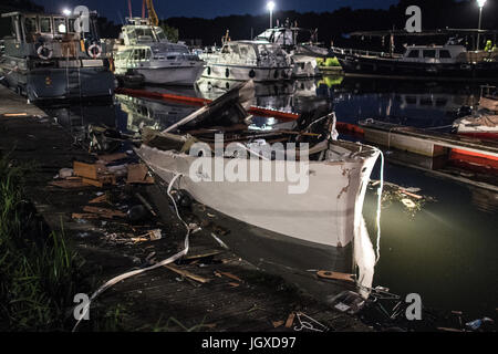 Minden, Deutschland. 12. Juli 2017. Die zerstörte Motoryacht "Gina" liegt im Hafenbecken halb versunkenen in Minden, Deutschland, 12. Juli 2017. Bei der Explosion einer Motoryacht am Hafen in Minden wurden zwölf Feuerwehrleute und Polizisten verletzt. "Sechs von Ihnen Erlitten zurück Verletzungen. Einer Schwebt in Lebensgefahr "(lit.) Sechs von ihnen erlitten schwere Verletzungen, stellt eine Gefahr für das Leben), sagte einen Sprecher der Polizei. Foto: Federico Gambarini/Dpa/Alamy Live News Stockfoto