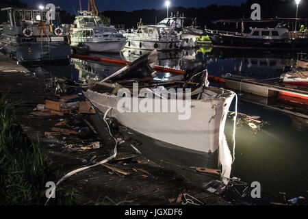 Minden, Deutschland. 12. Juli 2017. Dpatop - liegt die zerstörte Motoryacht "Gina" im Hafenbecken halb versunkenen in Minden, Deutschland, 12. Juli 2017. Bei der Explosion einer Motoryacht am Hafen in Minden wurden zwölf Feuerwehrleute und Polizisten verletzt. "Sechs von Ihnen Erlitten zurück Verletzungen. Einer Schwebt in Lebensgefahr "(lit.) Sechs von ihnen erlitten schwere Verletzungen, stellt eine Gefahr für das Leben), sagte einen Sprecher der Polizei. Foto: Federico Gambarini/Dpa/Alamy Live News Stockfoto