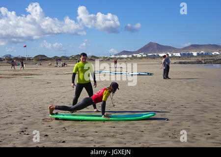 Trockenuebungen, Wellenreiter ueben mit Surfbrett am Famara Strand, La Caleta de Famara, Lanzarote, Kanarische Inseln, Europa | Training, Body surfer Stockfoto