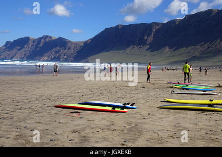 Surfer Mit Surfbrett bin Famara Strand, Aufsteigendes Famara Gebirge, La Caleta de Famara, Lanzarote, Kanarische Inseln, Europa | Körper-Surfer in Famara Stockfoto