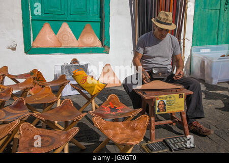 Handwerker fertigt klappstuehle mit lederauflagen, woechentlicher Sonntagsmarkt in Teguise, Lanzarote, Kanarische Inseln, Europa | Mann Handwerk camp-cha Stockfoto