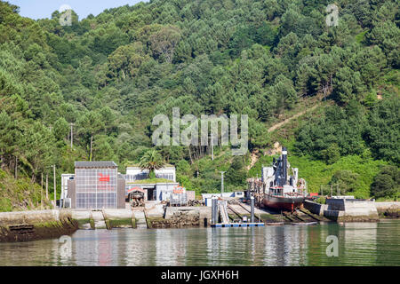 Einen Eimer Baggerarbeiten Schiff im Trockendock in den Fjord von Pasajes (Guipuzkoa - Spanien).  Pasajes (oder Pasaia) ist die San Sebastian Gewerbegebiet Hafen Stockfoto