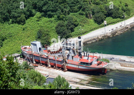 Einen Eimer Baggerarbeiten Schiff im Trockendock in den Fjord von Pasajes (Guipuzkoa - Spanien).  Pasajes (oder Pasaia) ist die San Sebastian Gewerbegebiet Hafen Stockfoto