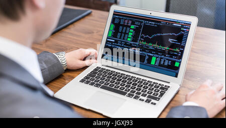 Junger Geschäftsmann Analyse wirtschaftliche Daten auf Laptop-Computer. Stockfoto