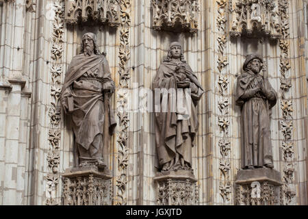 Heiliger Judas Thaddäus, Johannes der Evangelist und St. Jakobus. Statuen der Apostel auf dem Portal der Himmelfahrt (Puerta De La Asunción) der Kathedrale von Sevilla (Catedral de Sevilla) in Sevilla, Andalusien, Spanien. Stockfoto