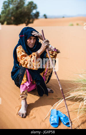 Porträt des alten Berber Frau sitzt auf einer Sanddüne in Merzouga, Marokko Stockfoto