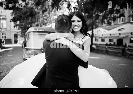 Super frisch verheiratetes Paar zu Fuß, posieren und Spaß im Park mit Hippie-van im Hintergrund. Schwarz / weiß Foto. Stockfoto