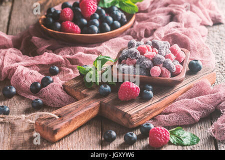 Getrockneten und kandierten Früchten und Beeren in Holzschale mit frischen Himbeeren und Heidelbeeren Stockfoto
