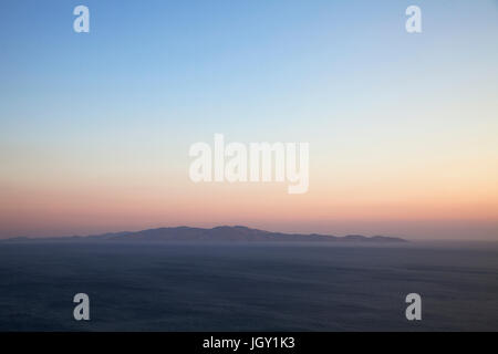 Seelandschaft und Fernsicht auf Andros Insel von Tinos Insel bei Sonnenuntergang, Griechenland Stockfoto