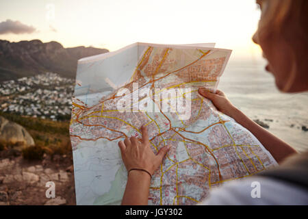 Junge Frau Wandern, Blick in die Karte, Lions Head Berg, Western Cape, Cape Town, Südafrika Stockfoto