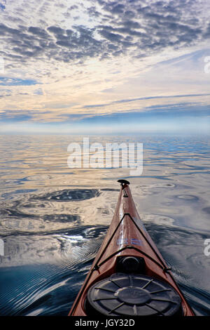 Ein Sea Kayak Position heraus in einer ruhigen, leeren Meer, Anglesey, Wales, Großbritannien Stockfoto