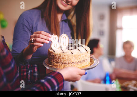 Tochter Vorbereitung Geburtstagskuchen für Mutter auf Geburtstagsparty Stockfoto