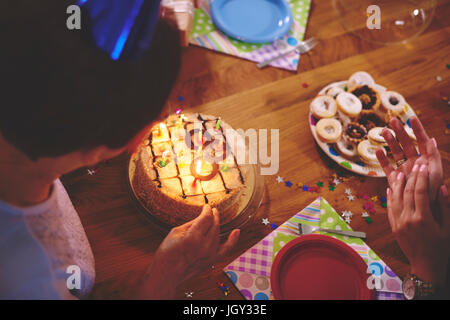 Ältere Frau betrachten Geburtstagskuchen auf party Stockfoto