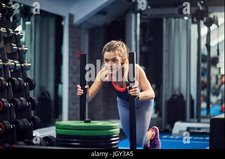 Junge Frau, training, Turnhalle Gewicht Schlitten einschieben Stockfoto