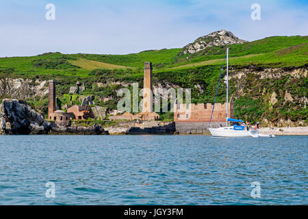 Eine Yacht ankern in Porth Wen auf der nördlichen Küste von Anglesey und die Website von einer verlassenen viktorianischen Ziegelei. Wales, UK Stockfoto