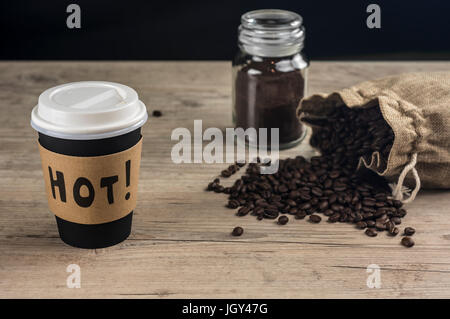 Schuss von nehmen Sie Kaffeetasse und Kaffeebohnen ergoss sich aus Jut Tasche hautnah Stockfoto