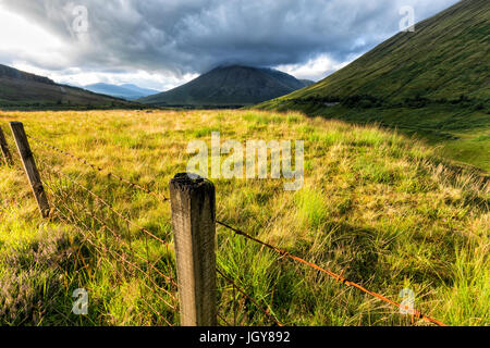 Zaunpfahl mit Beinn Dorain und Beinn Odhar in der Ferne. Stockfoto