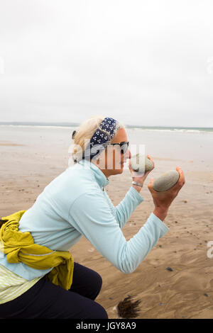 Ein Frauen praktizieren Pilates auf Newgale Sands in Pembrokeshire, Wales, Großbritannien. Stockfoto