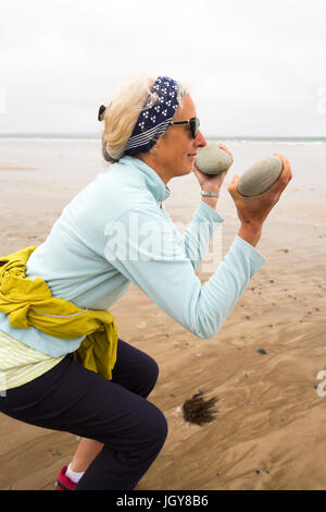 Ein Frauen praktizieren Pilates auf Newgale Sands in Pembrokeshire, Wales, Großbritannien. Stockfoto