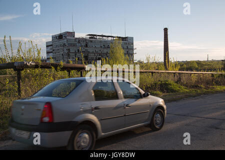 Neues Fahrzeug vorbeifahren an zerstörten Industriestandort Stockfoto