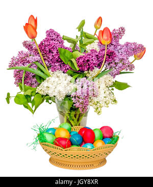 Bunte Ostereier und eine transparente Vase mit den Blumen: violette und weiße Syringa Vulgaris, rote Tulpen Stockfoto