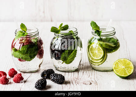 Drei Arten von Detox Wasser mit Brombeere, Erdbeere, lime auf weißem Hintergrund aus Holz. Stockfoto