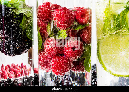 Drei Arten von Detox Wasser mit Brombeere, Erdbeere, lime mit Zutaten auf weißem Hintergrund aus Holz. Stockfoto