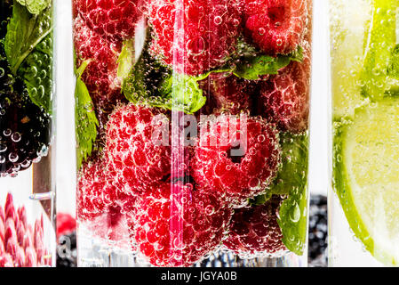 Drei Arten von Detox Wasser mit Brombeere, Erdbeere, lime mit Zutaten auf weißem Hintergrund aus Holz. Stockfoto