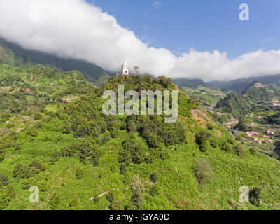 Kirche auf dem Berg mit Wolken Abstieg ins Tal, im malerischen Stadt Sao Vicente, die Insel Madeira, Portugal. Stockfoto