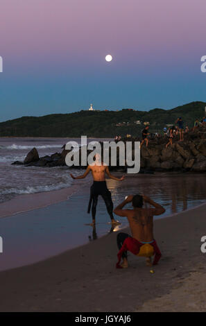 Menschen beobachten den Sonnenaufgang Set und Vollmond in Byron Bay, New South Wales, Australien. Stockfoto