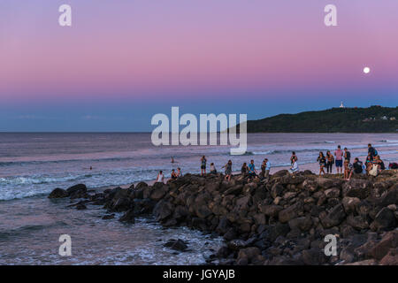 Menschen beobachten den Sonnenaufgang Set und Vollmond in Byron Bay, New South Wales, Australien. Stockfoto