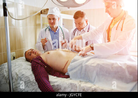 Junge talentierte Chirurgen die Operation auf ihre Patienten. Stockfoto