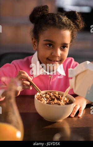 Porträt von lächelnden kleinen Mädchen zu Hause frühstücken Stockfoto