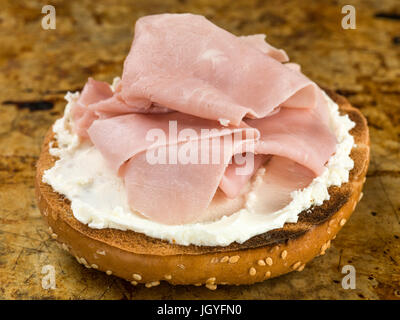 Schinken und Käse verbreiten Sesam Bagel sitzen auf einem Backblech Stockfoto