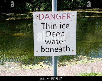 Schild an einem Kanal bank Gefahr Thin Ice tiefen Wasser unter Stockfoto