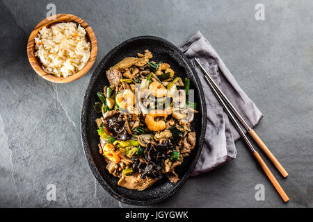 Chinesisches Essen. Te Pam Sao. Pfanne mit gebratenem Rind, Schwein, Huhn, Garnelen, Shiitake-Pilzen, Champions und Frühlingszwiebeln. Parillada China serviert mit Reis o Stockfoto