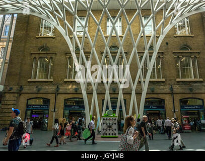 Die Menschen in der Halle am Bahnhof King's Cross, London, England, UK, vor der riesigen gewölbten Gitter Gitter Skulptur Dach von Arup