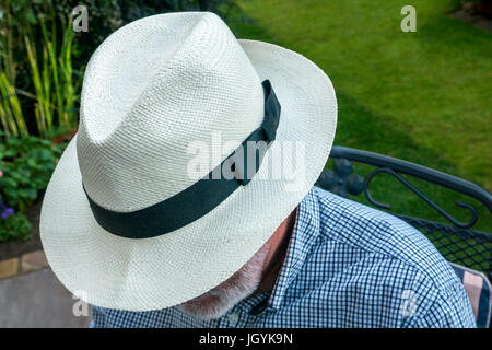 In der Nähe von älteren Mann mit weissen Bart draußen im Garten tragen eine Panama Hut mit seinem Gesicht versteckt, London, England, Großbritannien Stockfoto