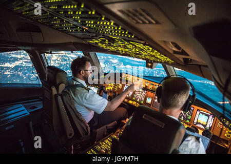 Zwei Piloten aus Dallas Fort Worth Airport abfliegen. Crew Ressource Management statt, beide arbeiten zusammen. Im Hintergrund Teile von Dallas Stockfoto