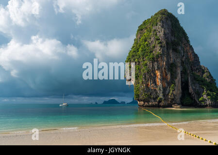 Einem großen hohen Felsen im Meer, Regenwolken über dem Meer. Weiße Yacht steht am Ufer Stockfoto