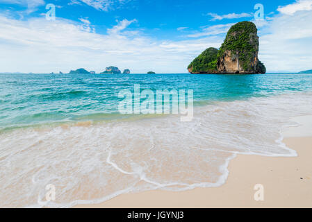 Türkis, sauberes Meer und weißer Schaum an der sandigen Küste von Thailand Stockfoto