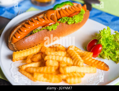 Bratkartoffeln und großen leckeren Hot Dog auf einem Teller Stockfoto