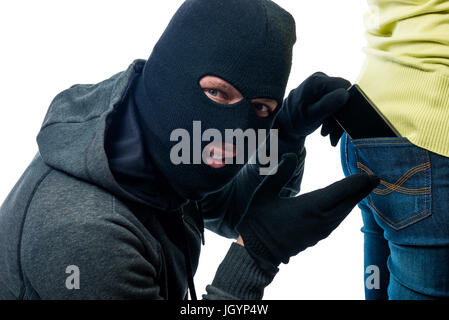 Telefon aus der Tasche auf der Rückseite-Jeans in der Maske zu stehlen Stockfoto