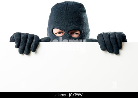 Porträt des Verbrechers in der Maske mit einem großen Plakat für die Inschrift Stockfoto