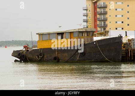 Ein Schlepper in den Prozess der konvertiert ein Sportboot gefesselt am Kai im Hafen von Hythe auf Southampton Water auf der südlichen Küste von En Stockfoto