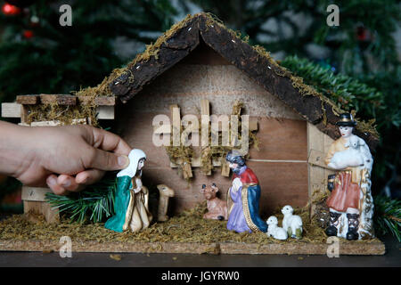 10-Year-Old Boy Verlegung eine Weihnachtskrippe. Frankreich. Stockfoto