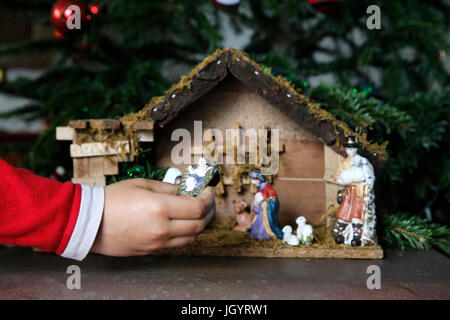 10-Year-Old Boy Verlegung eine Weihnachtskrippe. Frankreich. Stockfoto