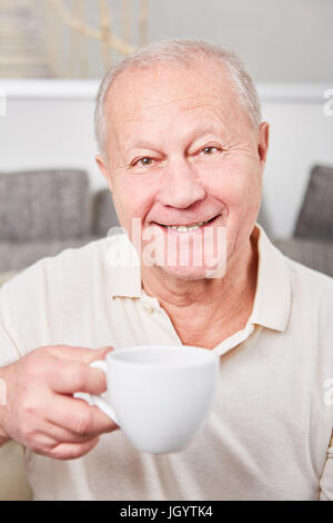 Zufrieden und glücklich senior woman mit einer Tasse Kaffee Stockfoto