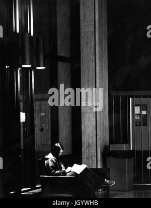 Johns Hopkins University Student sitzt auf einem Stuhl, lesen in der Bibliothek der Universität Milton S Eisenhower, in Baltimore, Maryland, 1965. Stockfoto